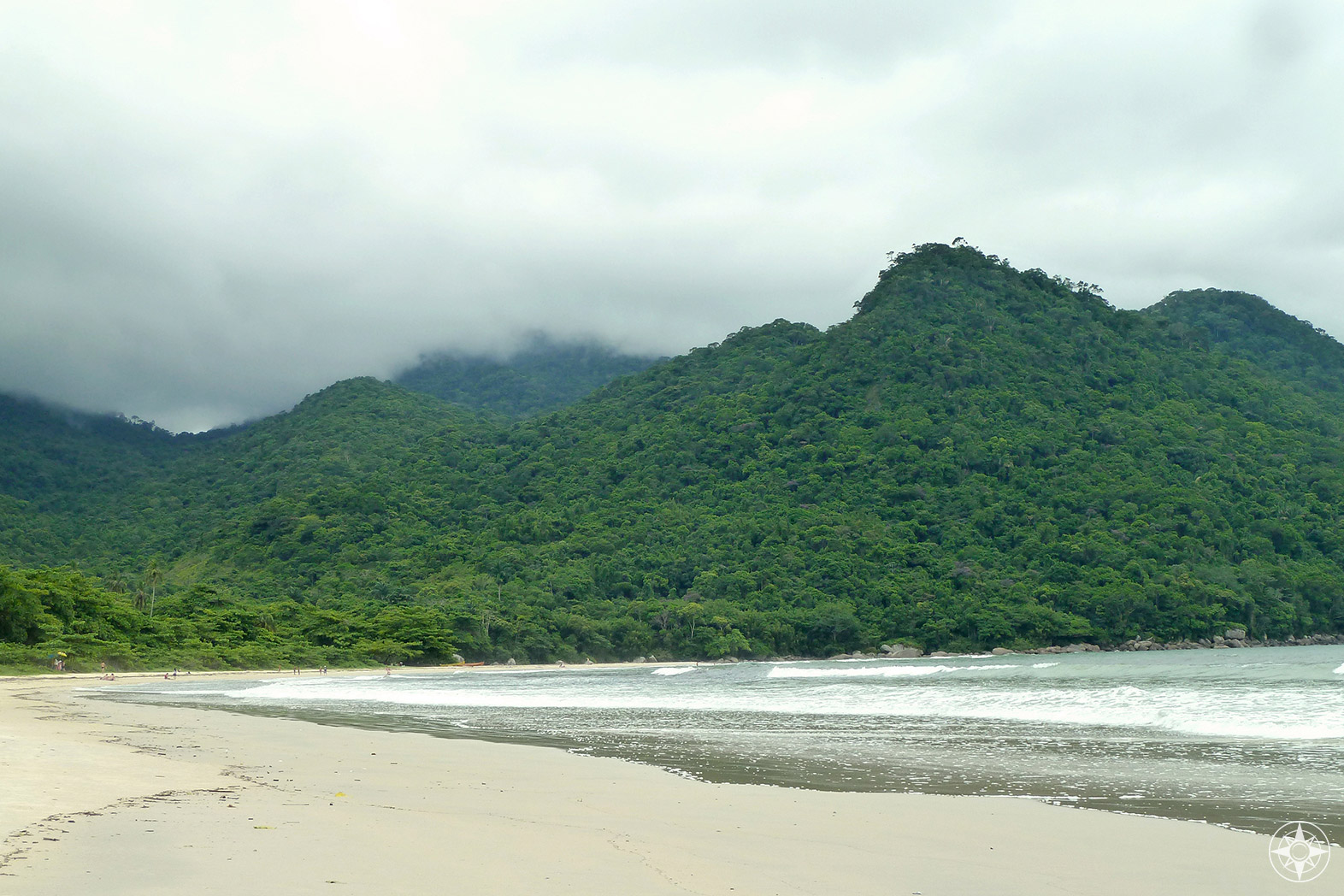 Atlantic rainforest covered hills disappearing into the clouds behind large and mostly empty Dois Rios beach on Ilha Grande, Brazil. Happier Place