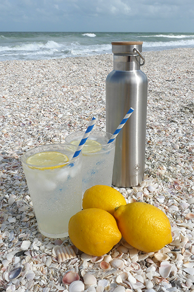 Vodka Collins and Happier Place insulated stainless steel bottle on the beach in Florida - Happier Place