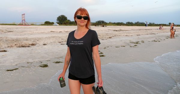 The First Happier Shirt by Happier Place on the beach in Florida at sunset.