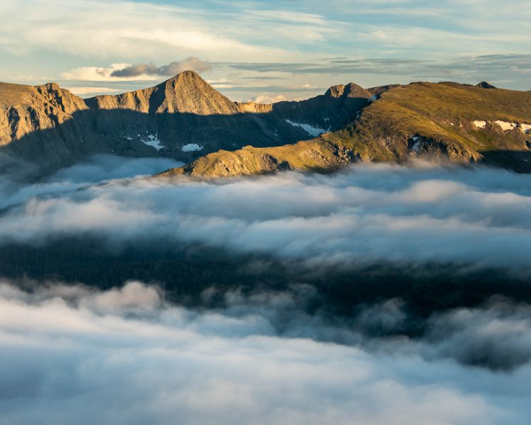 Sunny mountain peaks above the clouds. Photographer Bryan Clark