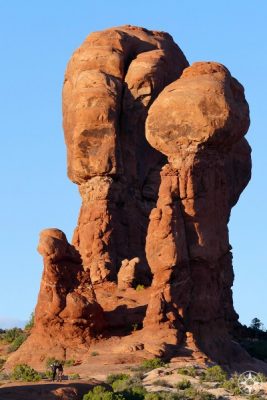 The two people in front of the sandstone rock formation give an idea of size in Arches NP.