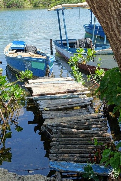 Small pier, smaller boat in the little harbor along the river in La Boca, Cuba.