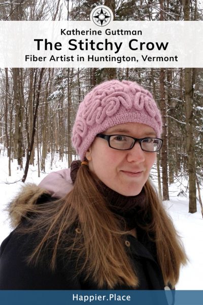 Fiber artist Katherine Guttman in her woods wearing a brainy hat. The Stitchy Crow
