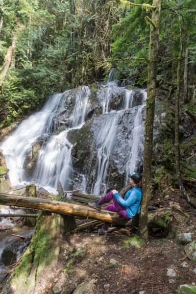 woman sitting by waterfall - Mystery Falls near Vancouver