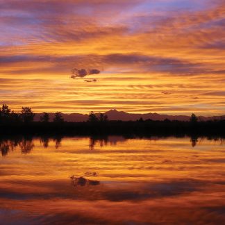 vibrant sunset sky and Rocky Mountains reflected in pond, St. Vrain State Park, Colorado, postcard