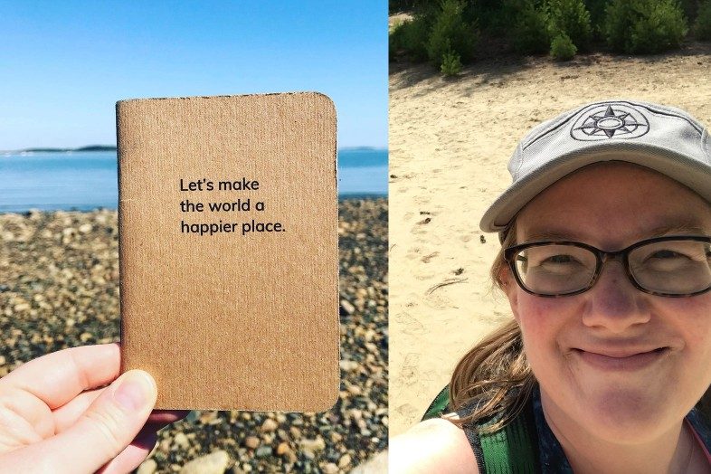 Kate showing off her Let's make the world a happier place notebook and Happier Place camper hat