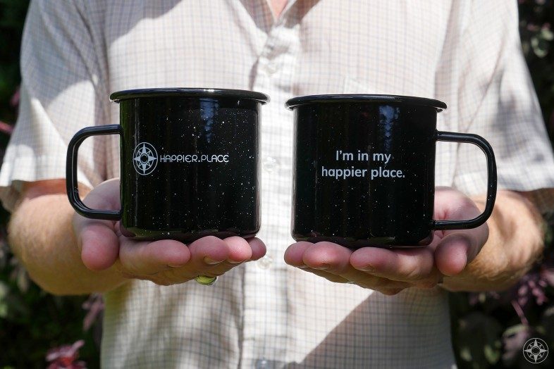 Black speckled "I'm in my happier place." enamel camping mug, front and back