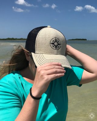 Happier Place burlap trucker hat with stitched on black compass logo