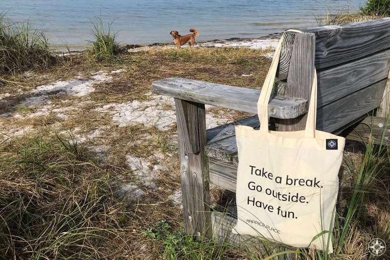 Take a break cotton shoulder bag hanging on beach bench, Happier Place, go outside, have fun, whiskey dog