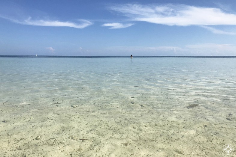 Picture yourself sitting on the beach with your feet in the shallow clear water and gazing out into the distance where the blue sky meets the sea, Florida Keys, Loggerhead Beach