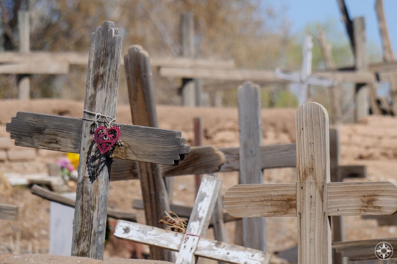 Wooden cemetery crosses and fence post crosses and a burgundy heart at Taos Pueblo cemetery, New Mexico