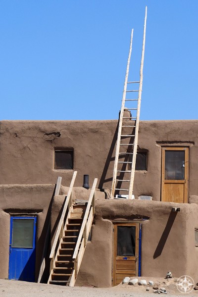 Doors, stairs and ladder reaching into the blue sky at UNESCO World Heritage Site Taos Pueblo, New Mexico. 