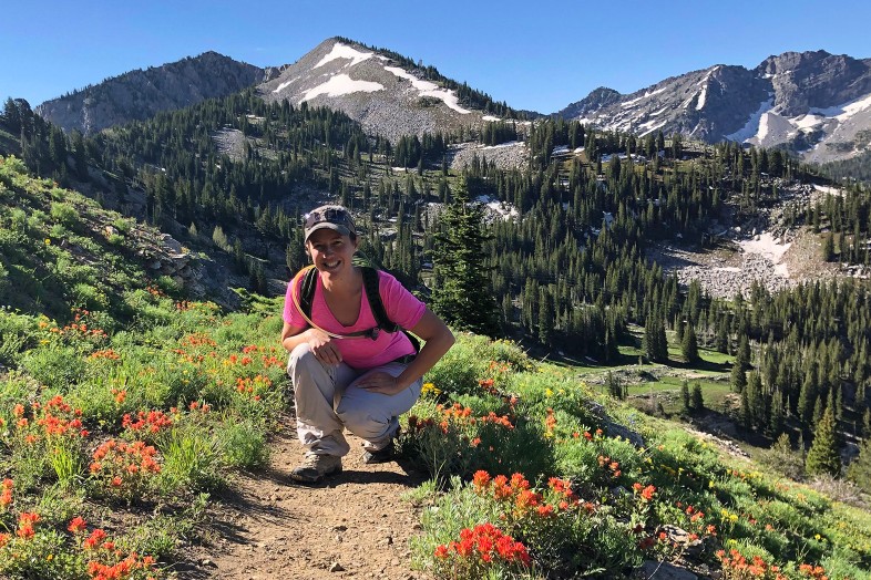 Outdoor adventure mystery novel author M.K. Dymock, creator of the Lost Gorge Mysteries, hiking on a mountain trail among wildflowers, Melissa, weekend woman warrior, Happier Place