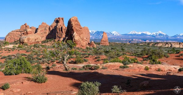 National Park Week at Arches National Park in Moab, Utah, red rock formations against snow-covered peaks and blue sky