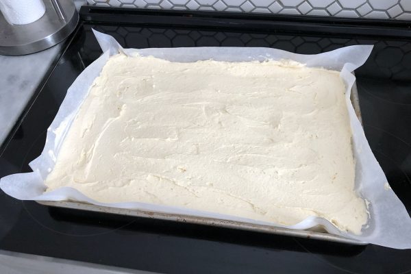 Spread out batter for sheet cake on parchment-paper lined baking sheet.